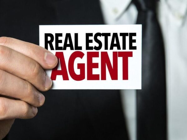 Image of a man holding up a card that says "Real Estate Agent" with the text "Million USA Realtors Email Database" below it.