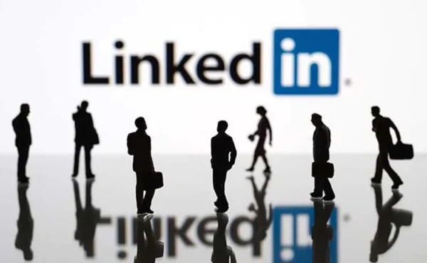 A diverse group of business people working on laptops and smartphones, with the LinkedIn logo above them. This image represents the USA CEO LinkedIn email database that GlobalBizData provides.